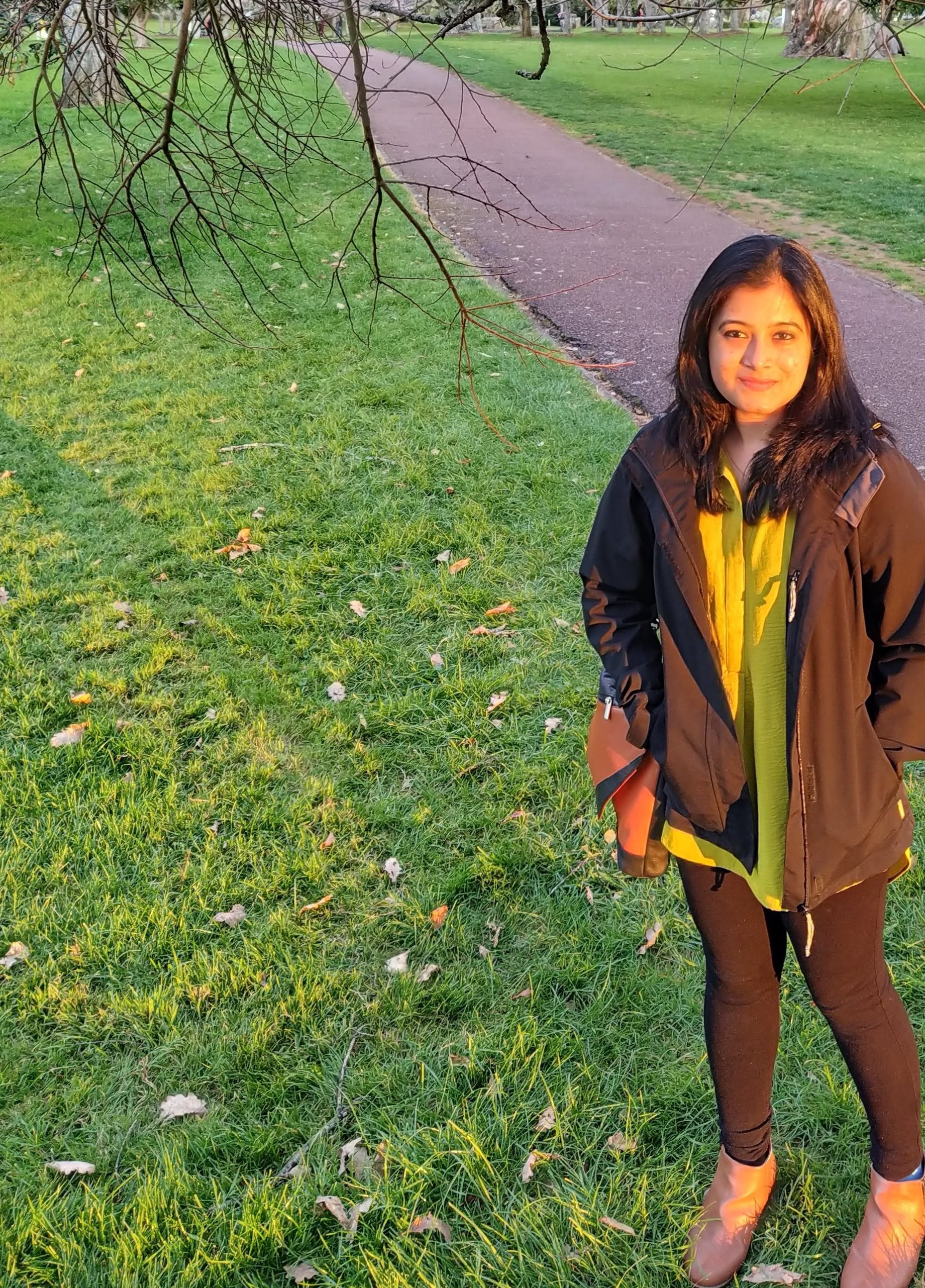 Photo of Nisha standing in a garden.