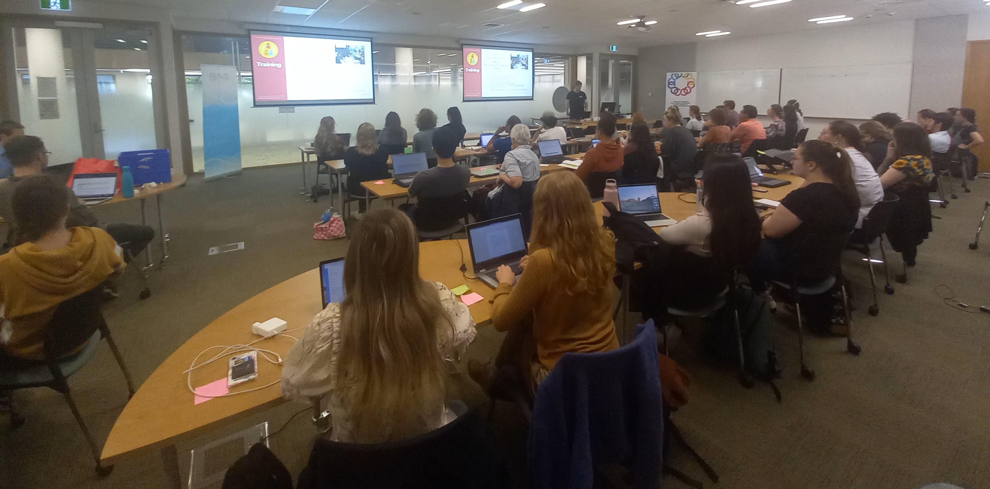 Photo from back of classroom of attendees at Otago Bioinformatics School listening to a presentation.