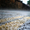 A close up view of rain drops hitting a road.